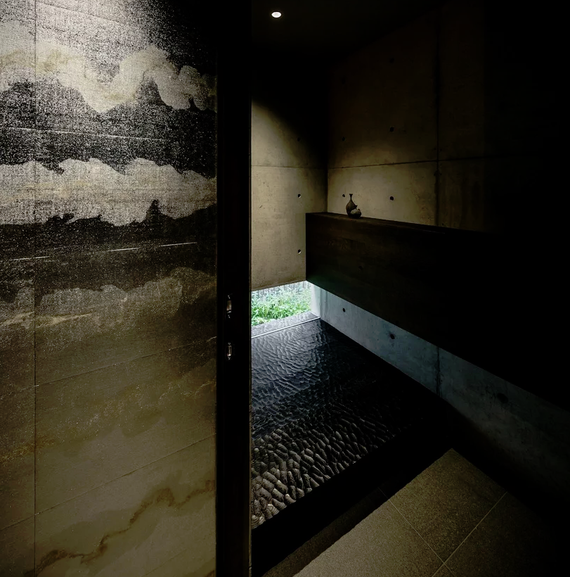 Natural stone and textural tiles plus dark wood make the shower space spa like