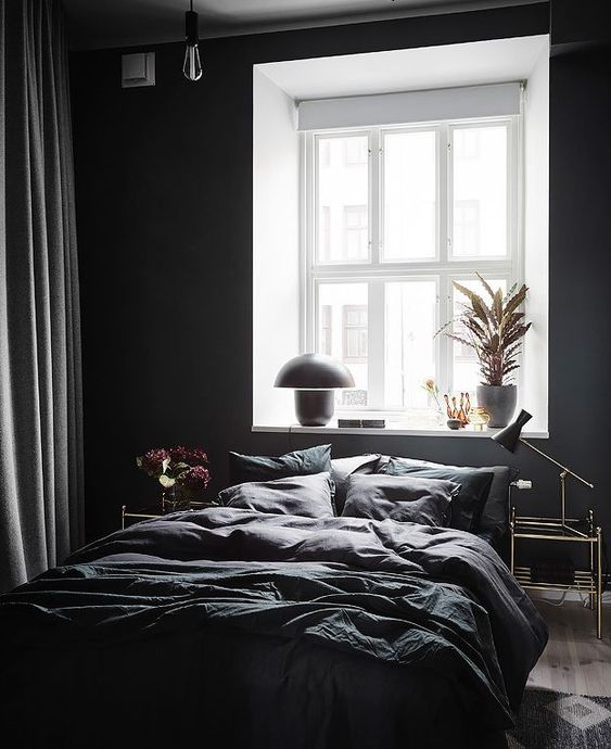 a contemporary bedroom with black walls, some bulbs and lamps and a dark bedding set