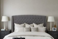 13 an elegant charcoal grey tufted wingback headboard, a crystal chandelier and a leather bench make up a glam modern space
