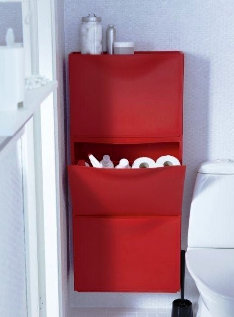 a bright red IKEA Trones piece attached to the wall and used for storing bathroom supplies