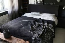15 a Nordic bedroom with black walls, a chic bedding set, artworks and white touches
