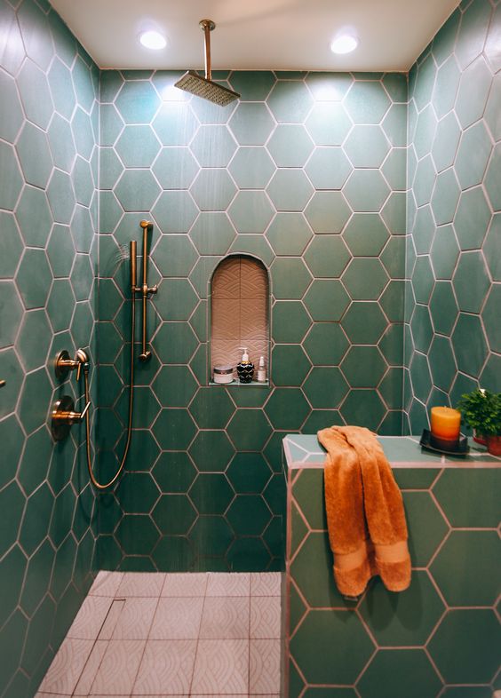 green hex tiles with copper grout make up a chic and bold bathroom space