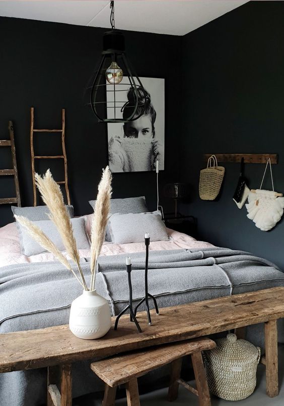a chic bedroom with black walls, grey and white touches, wood to warm up the space