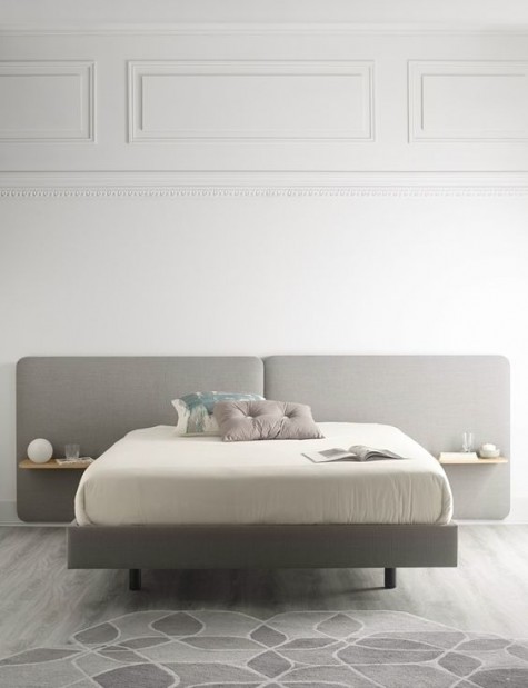 a modern grey upholstered headboard with floating nightstands attached is a laconic and stylish solution