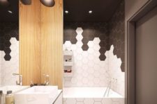 17 chic black and white hex tiles with conttrasting grout make up a chic geometric bathroom