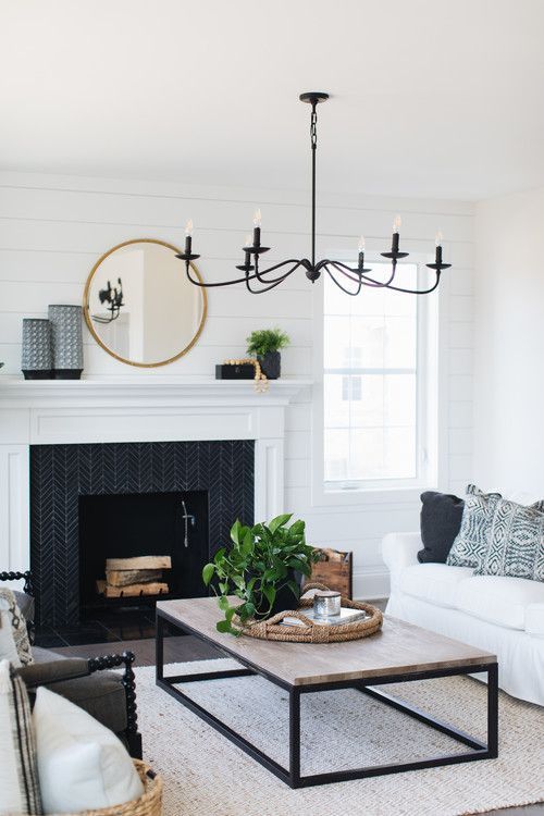 a black chanddelier imitating old candle ones contrasts the neutral space and adds drama