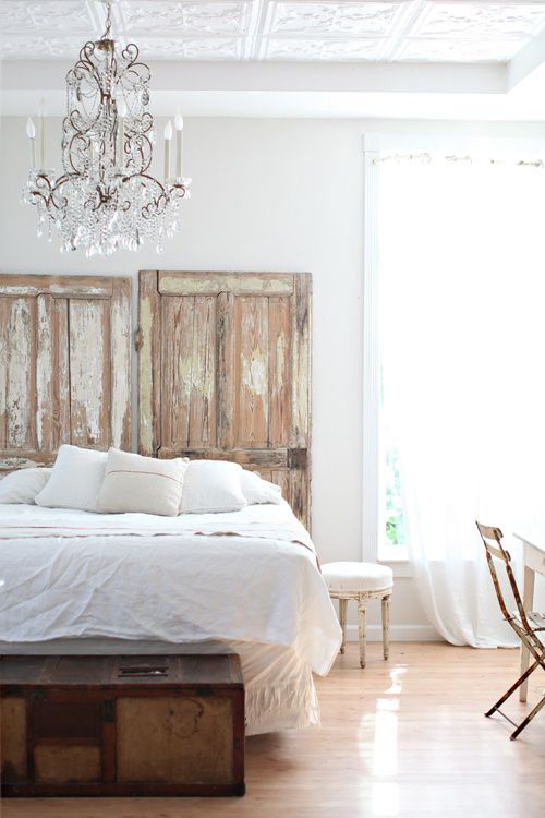 a light-filled and airy bedroom with a crystal chandelier, shabby chic doors looks very refined and elegant