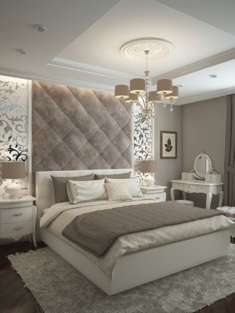 a refined taupe velvet headboard with padding comes up to the refined ceiling and adds a chic statement to the space