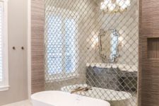 21 a wall done with reflective Moroccan tiles separates the bathtub from the rest of the space and accents it