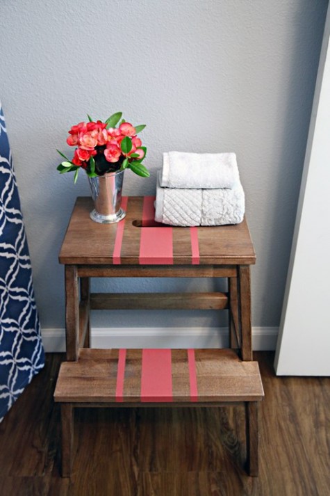 A convenient tub side storage unit of an Ikea Bekvam stool spruced up with a bit of coral paint and a stencil