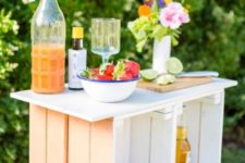 22 a pastel outdoor bar made of crates painted in pastel shades and with a wooden tabletop