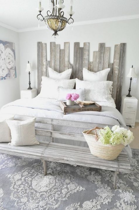 a shabby chic greyish headboard made of planks of different height for a nonchalant feel in the space