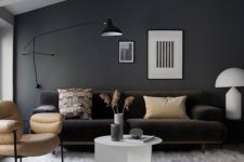 23 a black wall sconce matches the style and colors of this living room providing some cozy light