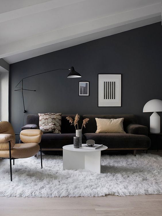 a black wall sconce matches the style and colors of this living room providing some cozy light