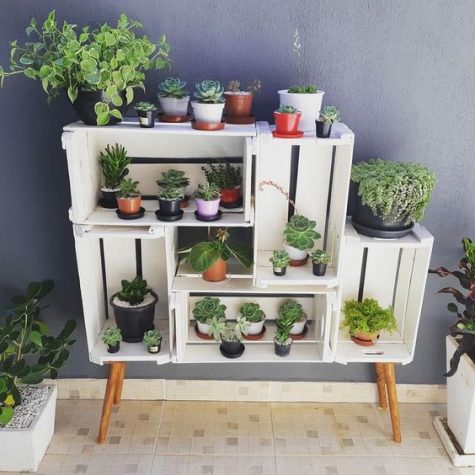 a simple and chic garden made of crates and wooden legs is a cute idea of an open storage unit