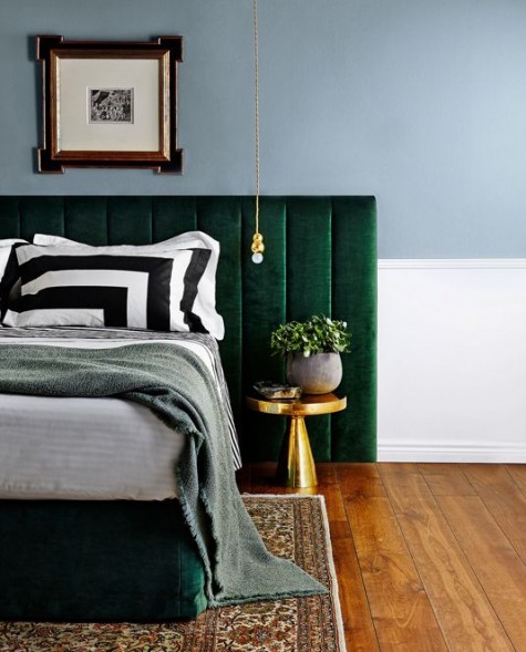an emerald velvet padded headboard is accented with brass touches and looks really outstanding
