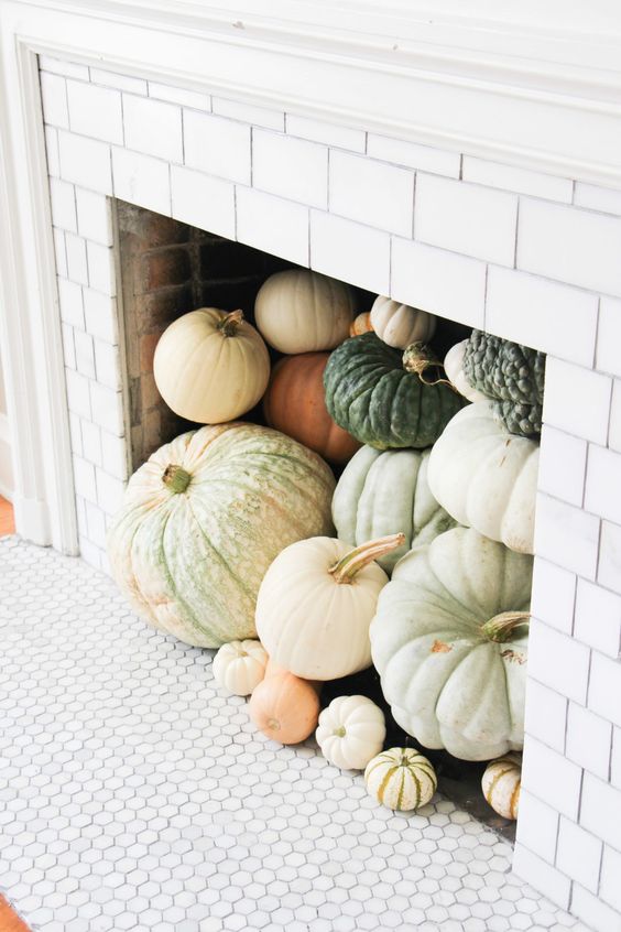 a non-working fireplace fully filled with heirloom pumpkins is an amazing fall idea