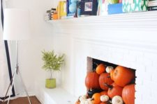29 a non-working fireplace filled with various pumpkins for the fall and coming Halloween