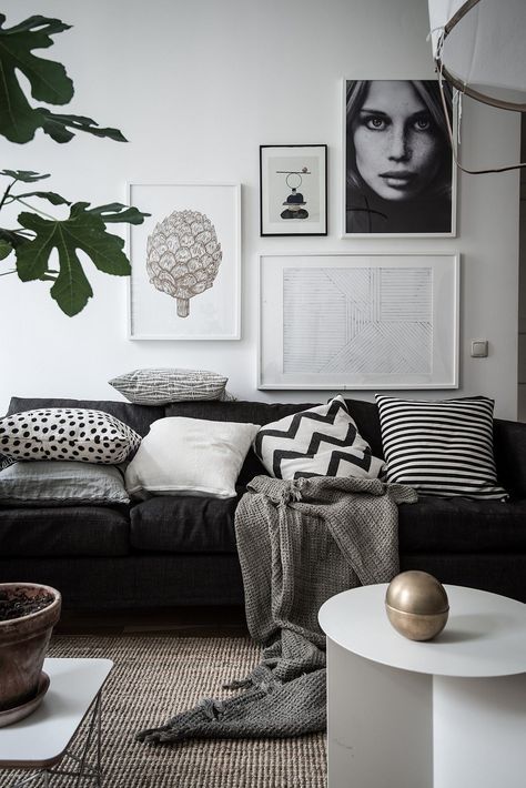 a Scandinavian living room with a gallery wall, greenery and a coffee table in white plus a gold touch
