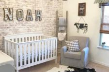 a farmhouse nursery with a whitewashed brick wall, an animal skin rug, grey furniture and a vintage chandelier