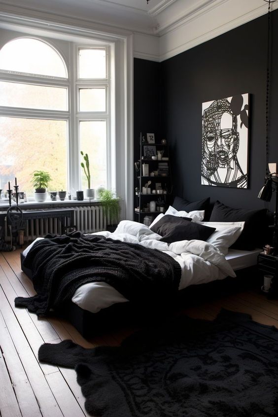 a lovely black and white bedroom with a black accent wall, a black bed and black and white bedding, a bookshelf and some decor