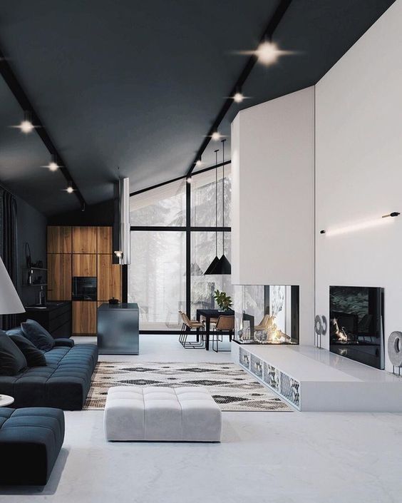 A minimalist living room with a built in firpelace, a sleek platform, black and white furniture and simple lights
