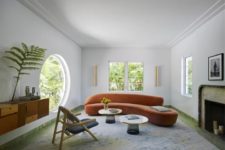 a modern luxurious living room with a large round window, which allows amazing views, and a usual one