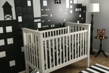a modern monochromatic nursery with a white crib, a striped rug, an ombre sequin chandelier and a marquee monogram