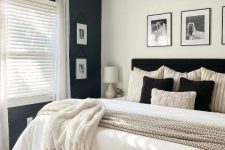 a simple and stylish black and white bedroom with a black accent wall, a black bed and monochrome bedding, blankets and pillows