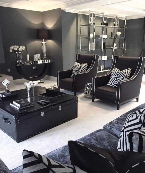 a stylish living room done in mostly black and graphite grey with touches of white to refresh the space and vintage furniture
