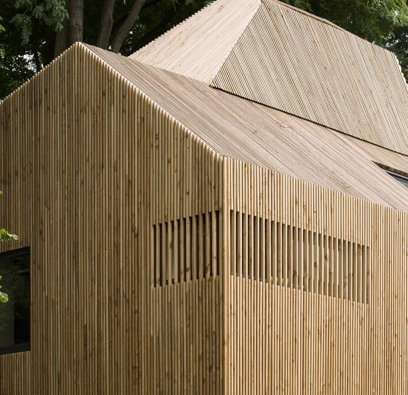 The house is fully clad with wood to highlight its lines and shapes and to contrast  the original home