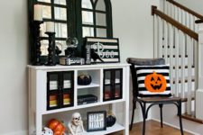 03 a bright Halloween entryway with skeletons, pumpkins, signs and a pumpkin pillow is easy to realize