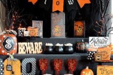 04 a bold food station for Halloween decorated with lights, bunting, letters, signs and colored glasses and cauldrons