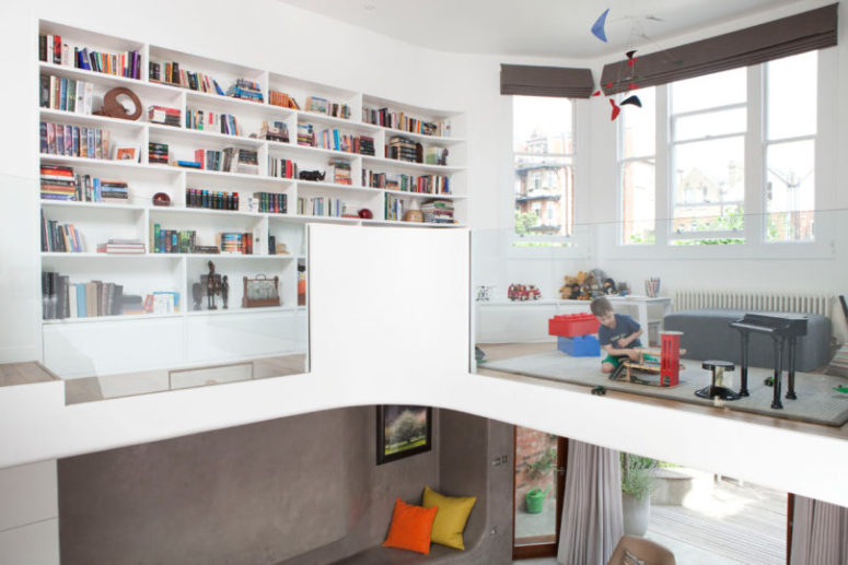 The upper floor features a play zone for the kid and a large built-in bookcase, there's much light coming through the windows