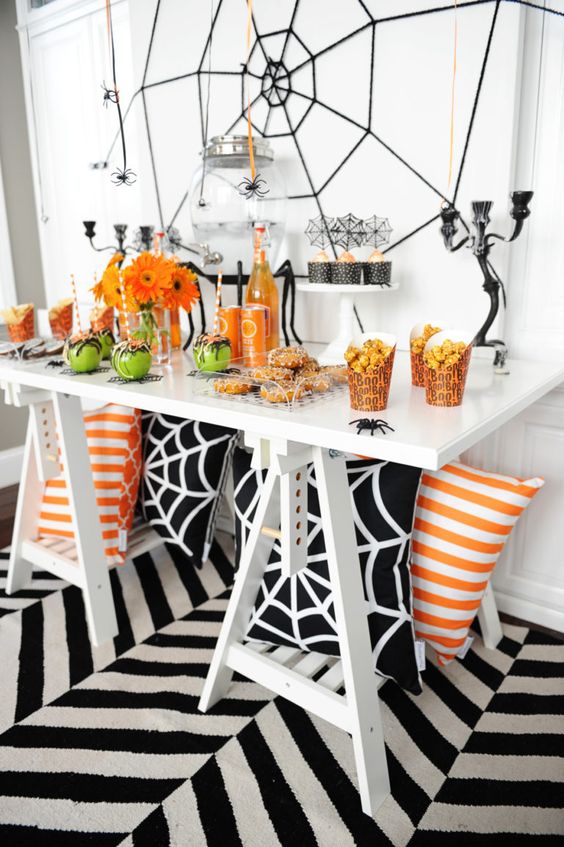 a bold Halloween buffet in black, white, orange and green, with spiderwebs and bright blooms
