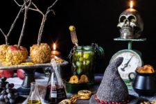 06 a buffet table styled with a sparky witch hat, some potion in bottles, a skull candleholder and some creepy treats