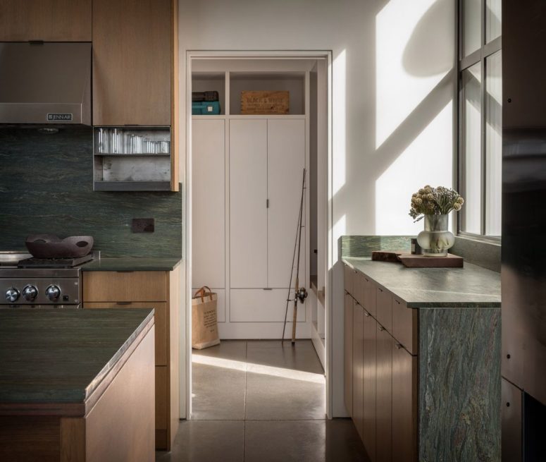 The kitchen is done with light-colored wood and green stone
