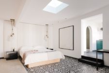07 The master bedroom is done with a skylight, some pendant lamps, a tile floor and a statement artwork