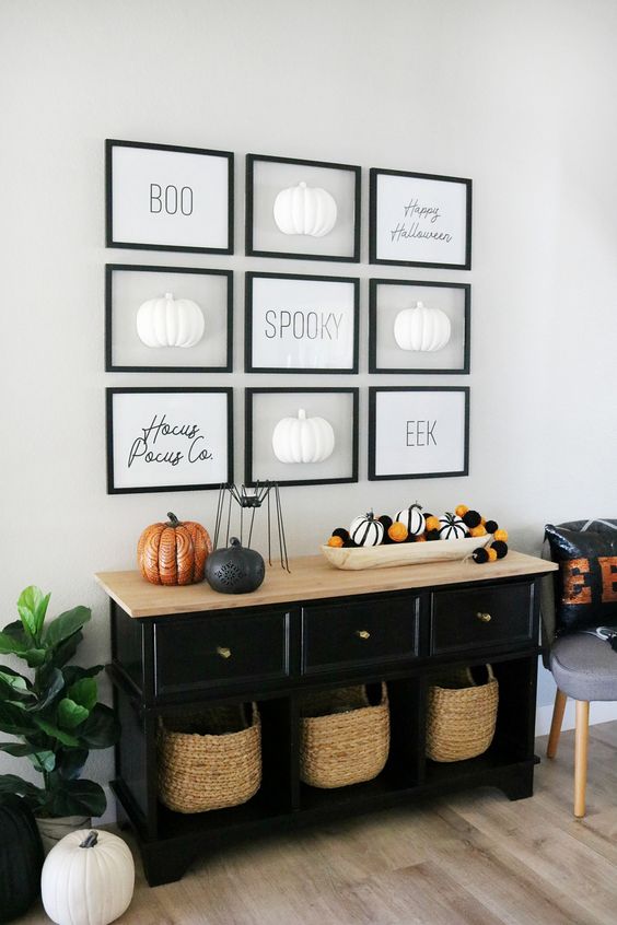 a Halloween entryway console with striped and black and orange pumpkins, a gallery wall with pumpkins and words