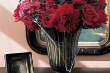 07 a moody vintage urn with sumptuous red blooms and some spiderweb is a traditional Halloween option that always works