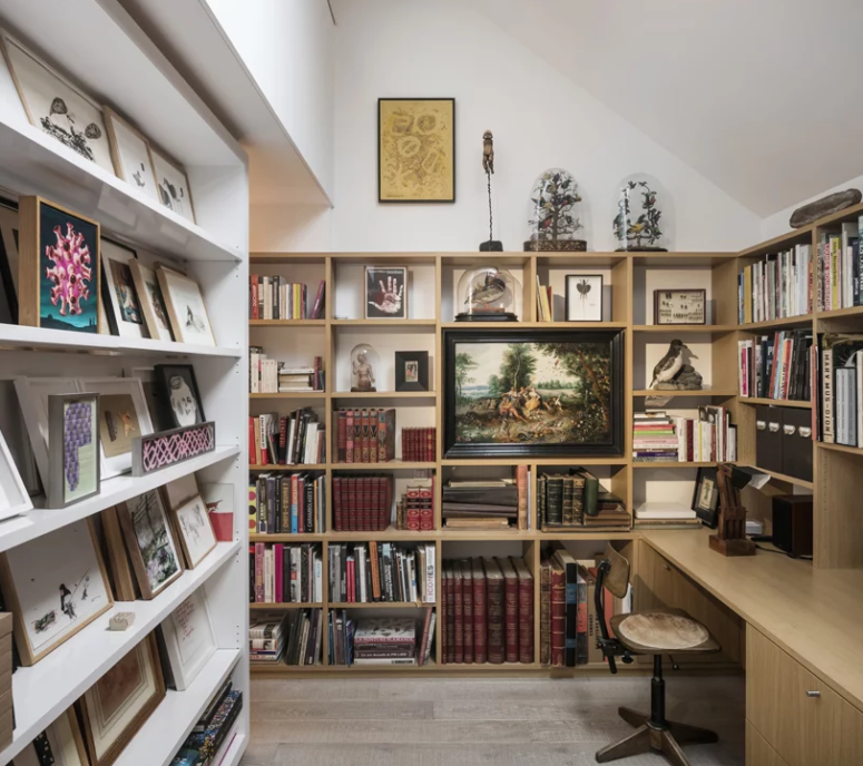 The study features endless bookshelves and a built-in desk plus some artworks