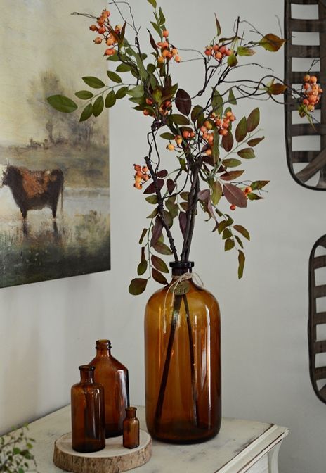fresh branches with greenery and berries put into amber bottles will make nice fall decor