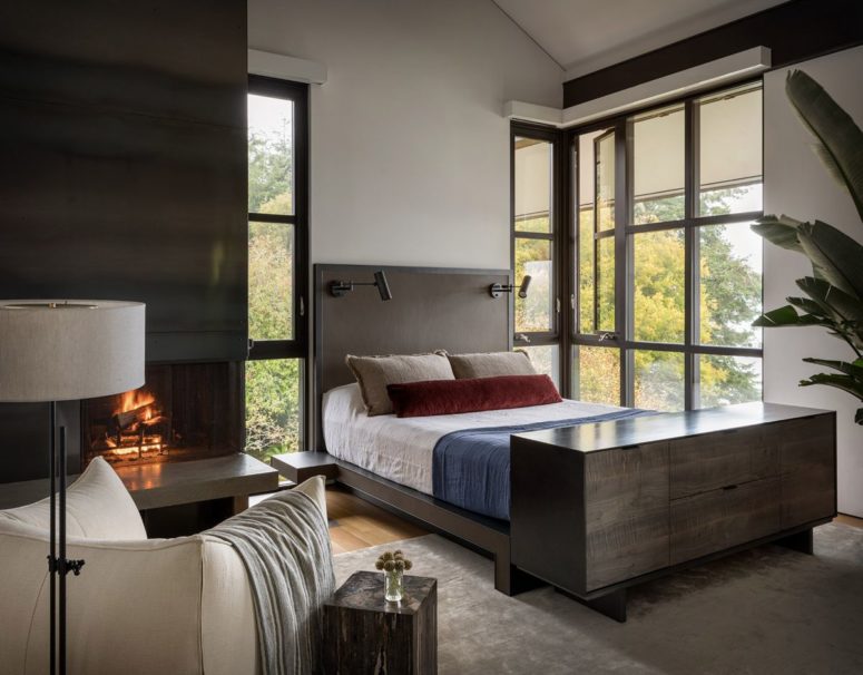 The bedroom features dark wood and metal, a hearth and amazing views