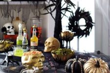 09 a stylish Halloween food station with skulls, lights, studded pumpkins, spiders and skeletons plus tasty food