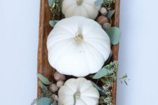 10 a fall centerpiece of a wooden bowl, acorns, greenery and white pumpkins – everything natural here