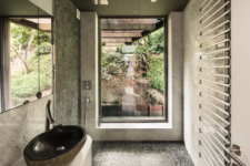 11 The bathroom opens towards nature and is decorated with pebbles and marble tiles