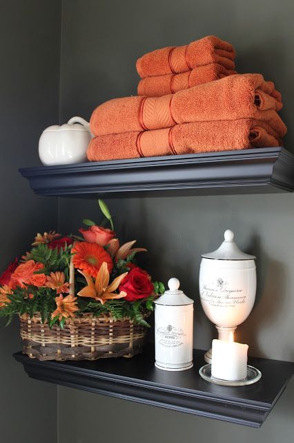 orange towels and a bright fall bloom arrangement in a basket will make your bathroom feel like fall