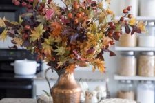 13 a beautiful fall arrangement of fall leaves and berries in a vintage metal jug is amazing for home decor