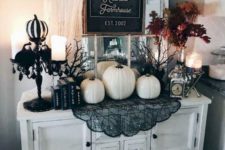 13 a white entryway console with white pumpkins, black lace, black and white pumpkins, candles and a fall leaf arrangement