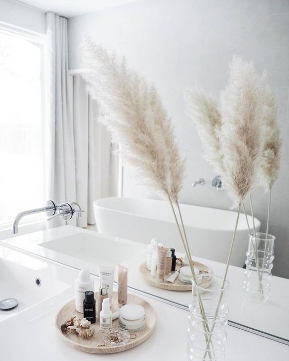 a dried grass arrangement in a clear vase is a cool fall accent for a contemporary or minimalist bathroom